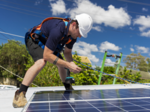 image of electrician installing solar panels on roof - for Solar Panels for Granny Flats Sydney contact Premier Granny Flats today